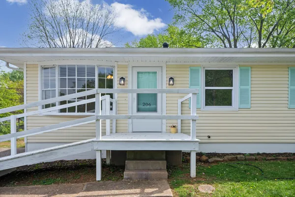 a backyard of a house with wooden deck and furniture