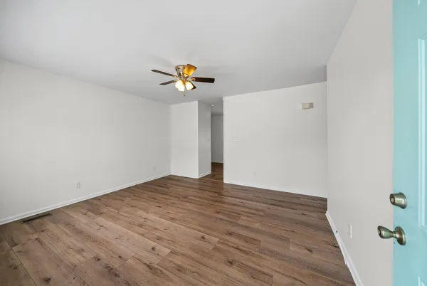 a view of an empty room with wooden floor