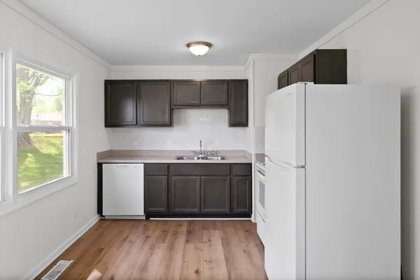 a kitchen with a refrigerator sink and cabinets