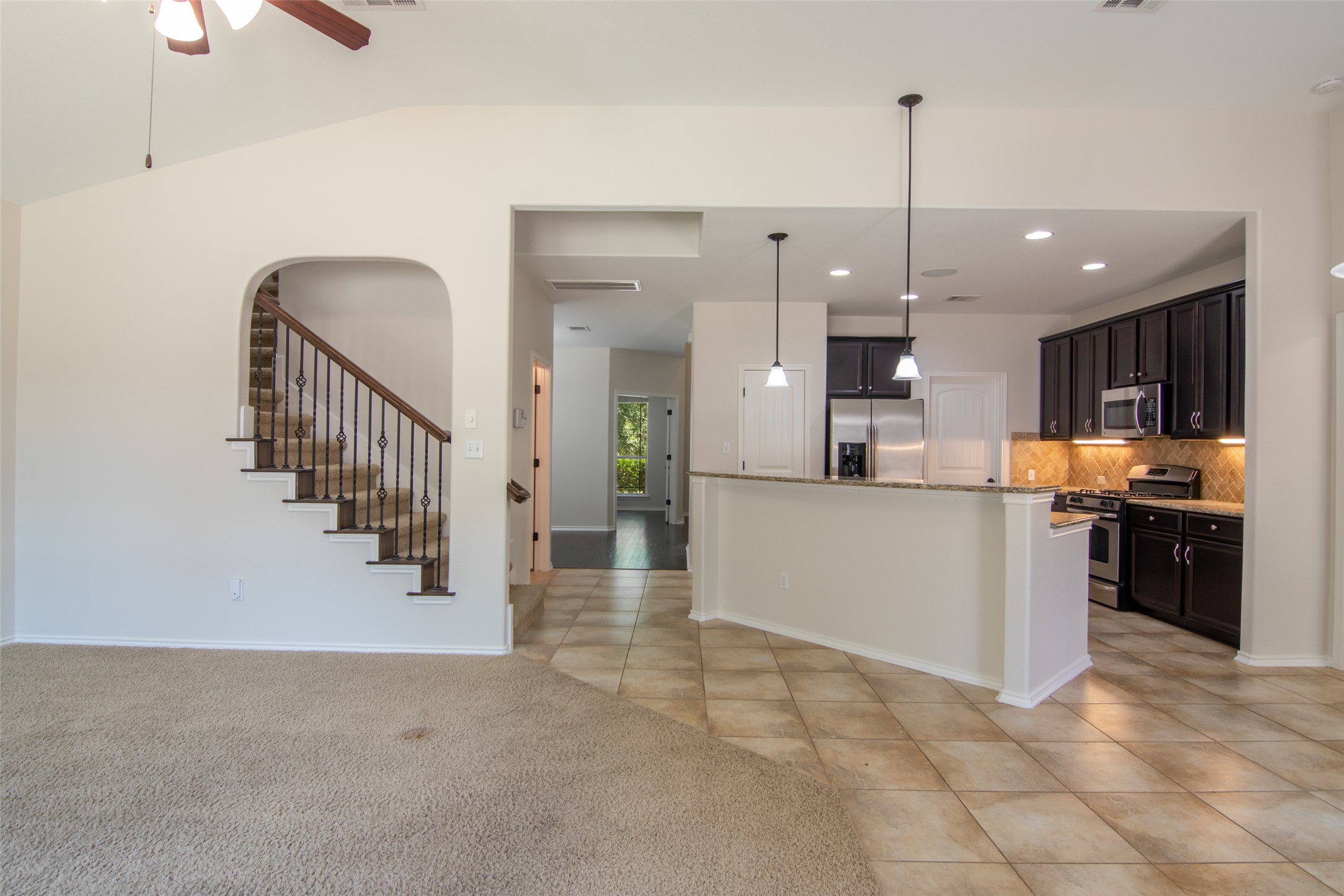 12104 Broten Street Austin, TX 78748 - Photo 32 of 32 An open floorplan seamlessly connects the living space to a modern kitchen and inviting staircase.