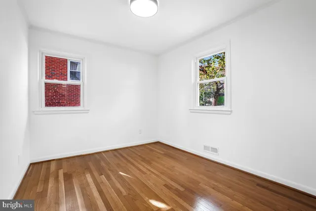 an empty room with wooden floor and fireplace