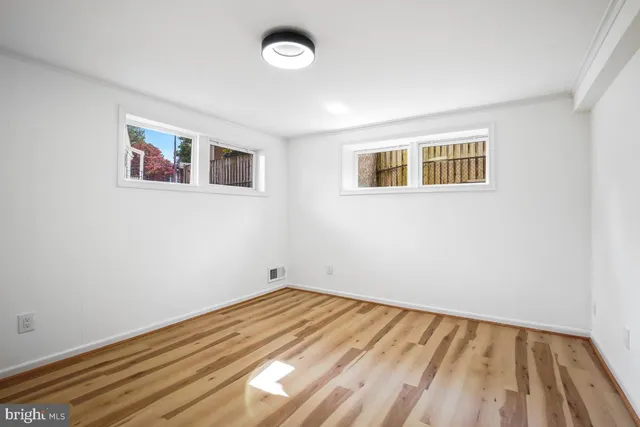 a view of a small space with wooden floor and a window