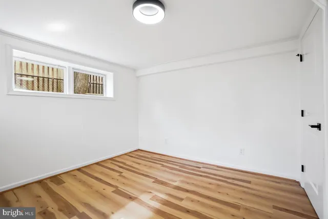 a view of a room with wooden floor and a window