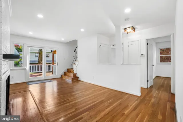 a view of a bedroom with wooden floor and a floor to ceiling window