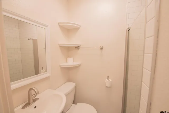 a bathroom with a toilet sink and shower