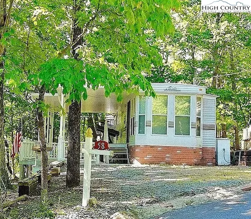 a view of a house with a tree in front of it