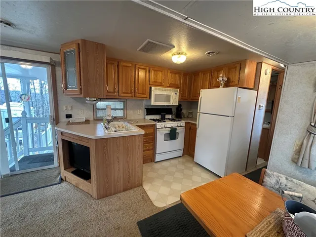 a kitchen with a refrigerator sink and wooden cabinets