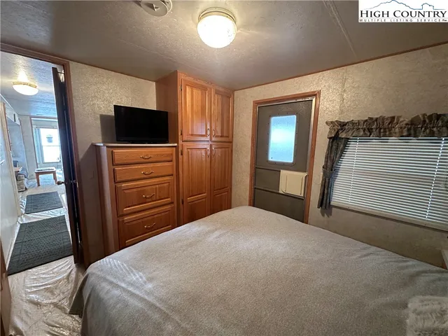 a bedroom with a bed and a flat screen tv