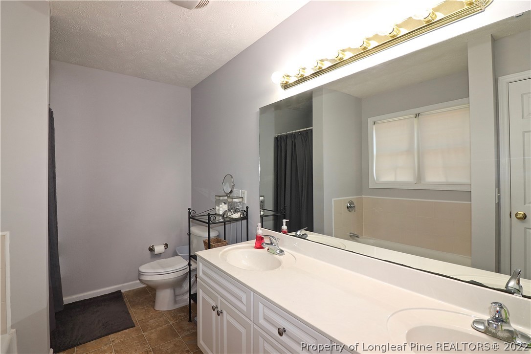 25 Fox Run Road Pinehurst, NC 28374 - Photo 17 of 28 a bathroom with a sink a toilet and mirror