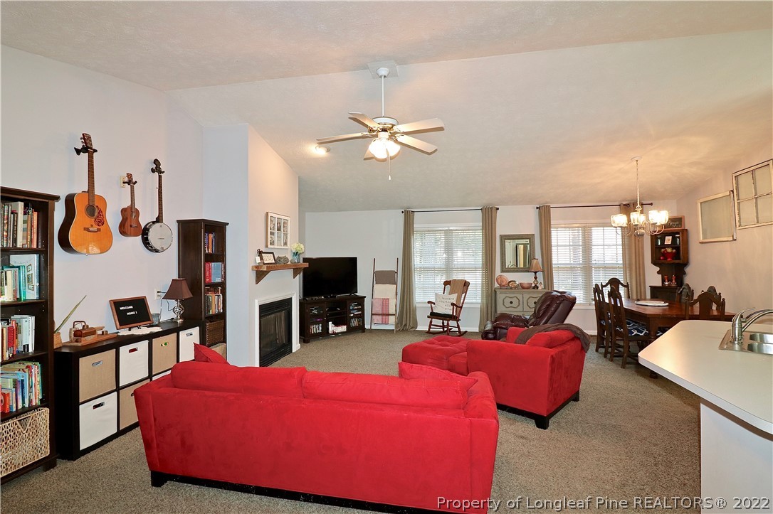 25 Fox Run Road Pinehurst, NC 28374 - Photo 3 of 28 a living room with furniture a flat screen tv and a fireplace