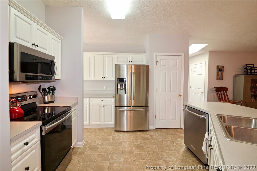 25 Fox Run Road Pinehurst, NC 28374 - Photo 8 of 28 a kitchen with stainless steel appliances granite countertop a refrigerator stove and sink