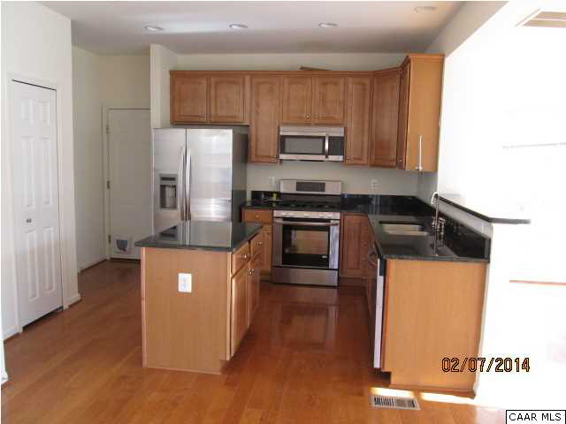 655 Reedy Creek Road Louisa, VA 23093 - Photo 4 of 10 a kitchen with stainless steel appliances granite countertop a stove a sink and a refrigerator with wooden floor