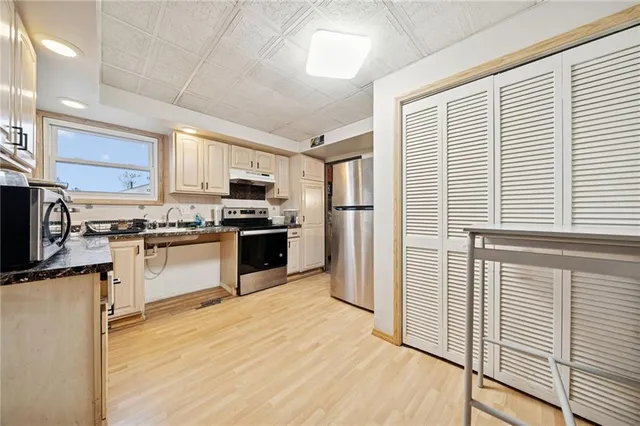 a kitchen with stainless steel appliances granite countertop a refrigerator and a stove top oven