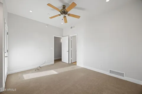 an empty room with a ceiling fan and wooden floor