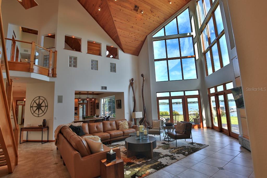 11035 Southeast Sunset Harbor Road Summerfield, FL 34491 - Photo 20 of 97 a living room with furniture a fireplace and large windows