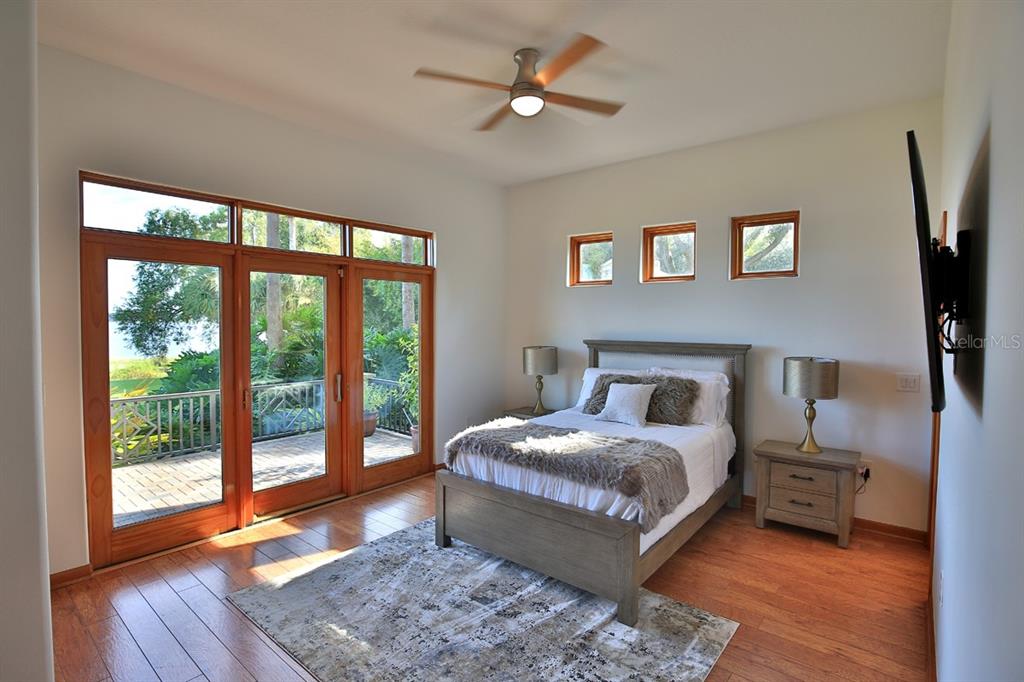 11035 Southeast Sunset Harbor Road Summerfield, FL 34491 - Photo 23 of 97 a bedroom with a bed a flat screen tv and a large window with the outer view