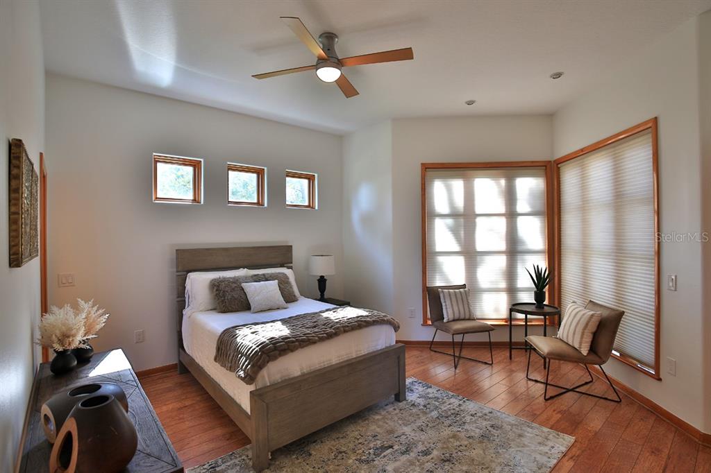 11035 Southeast Sunset Harbor Road Summerfield, FL 34491 - Photo 25 of 97 a bedroom with a bed wooden floor and a window