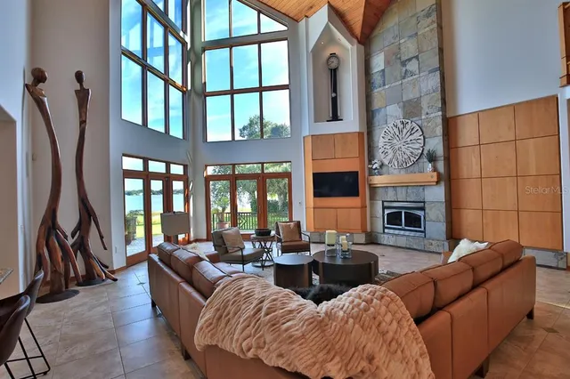 a bedroom with a bed a flat screen tv and a large window with the outer view