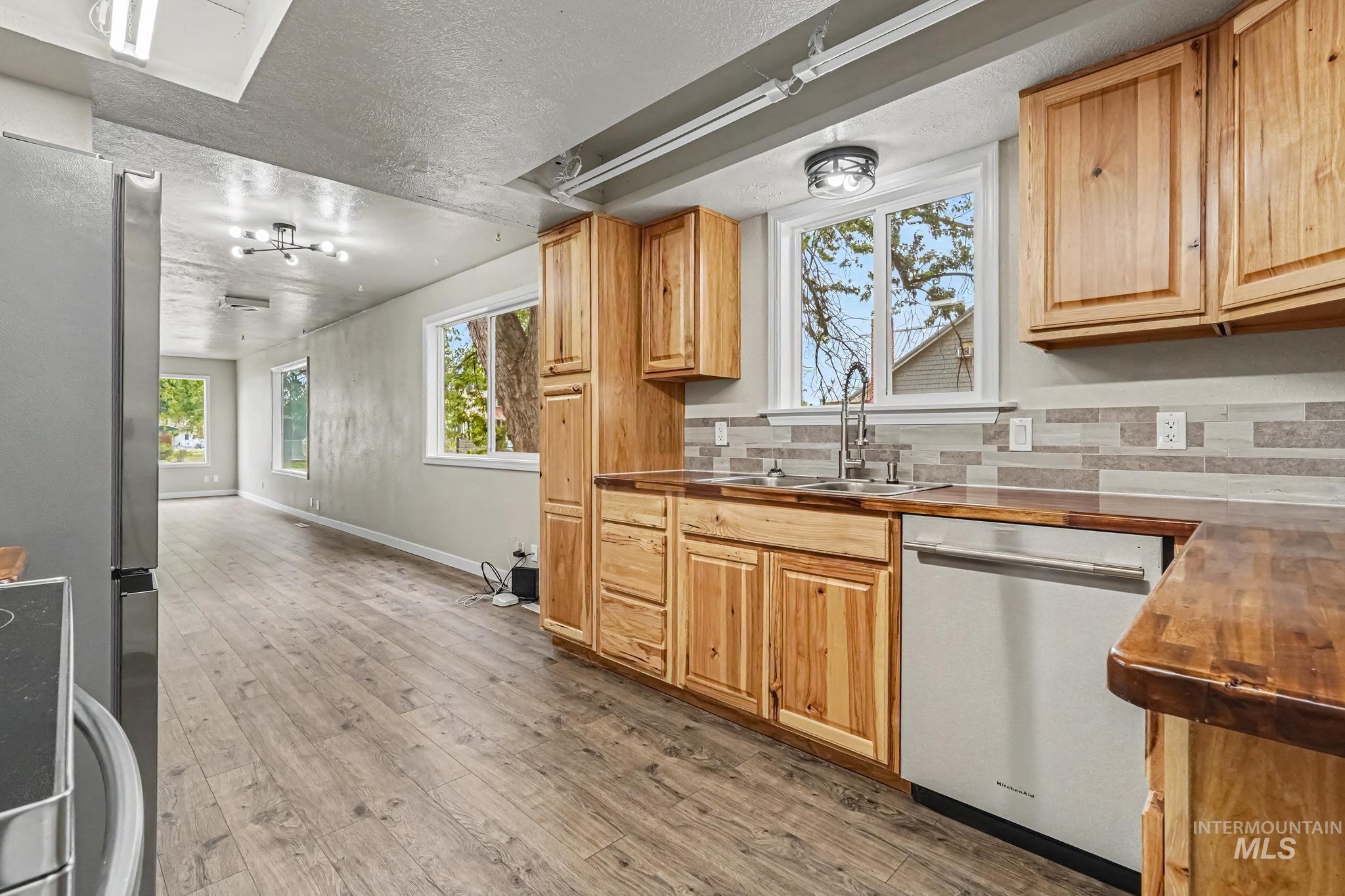 1023 State Street Weiser, ID 83672 - Photo 8 of 25 Kitchen featuring natural wood cabinetry, wood-finish countertops, stainless-steel appliances, and a mosaic tile backsplash