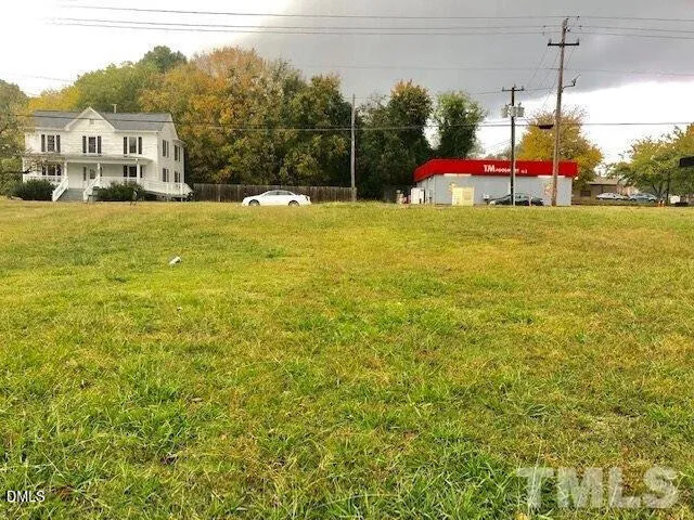 a view of a house with a big yard and large trees