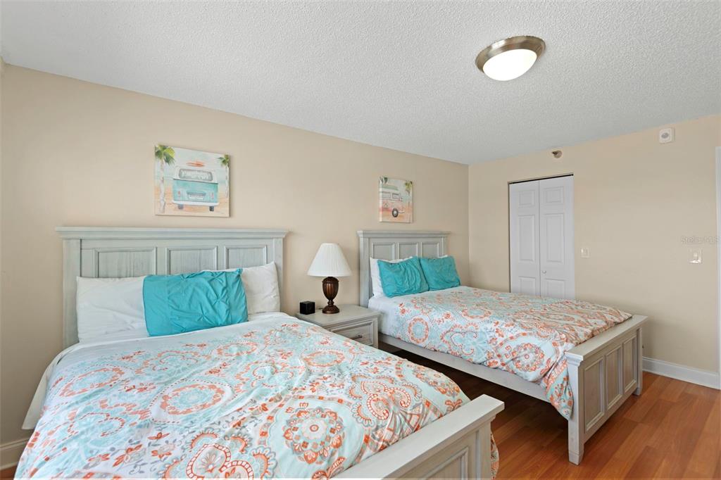 13440 Gulf Lane, Unit 202 Madeira Beach, FL 33708 - Photo 14 of 41 a bedroom with two beds and a lamp