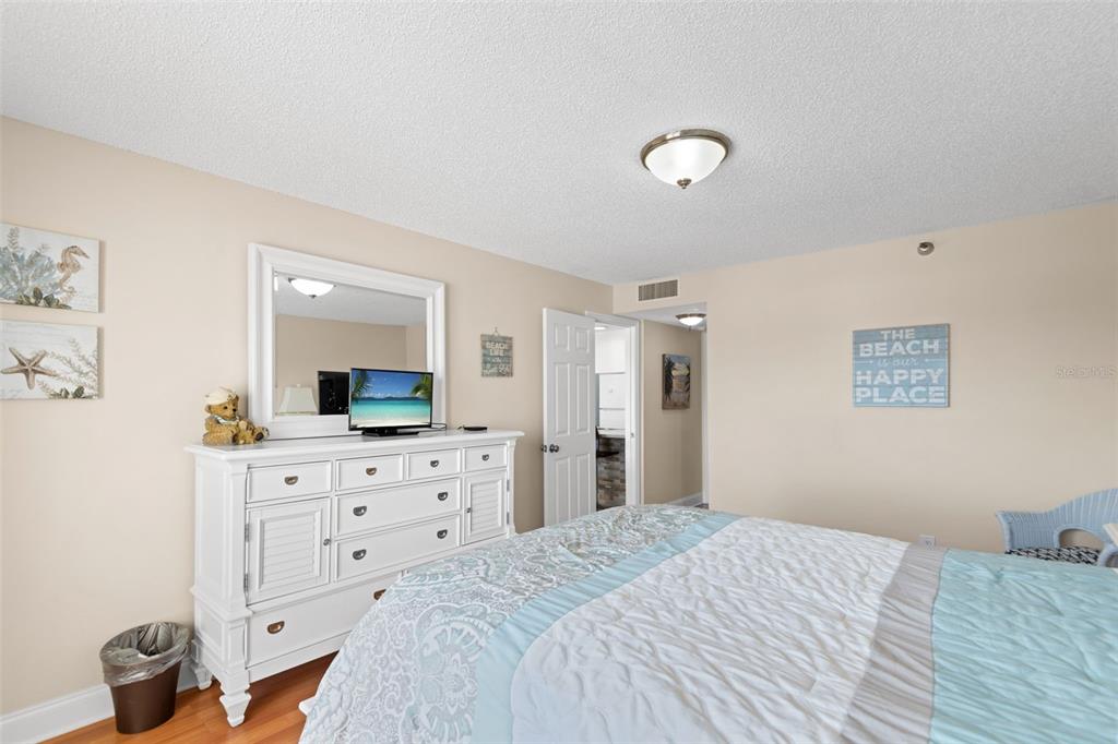 13440 Gulf Lane, Unit 202 Madeira Beach, FL 33708 - Photo 20 of 41 a bedroom with a bed and a dresser in it