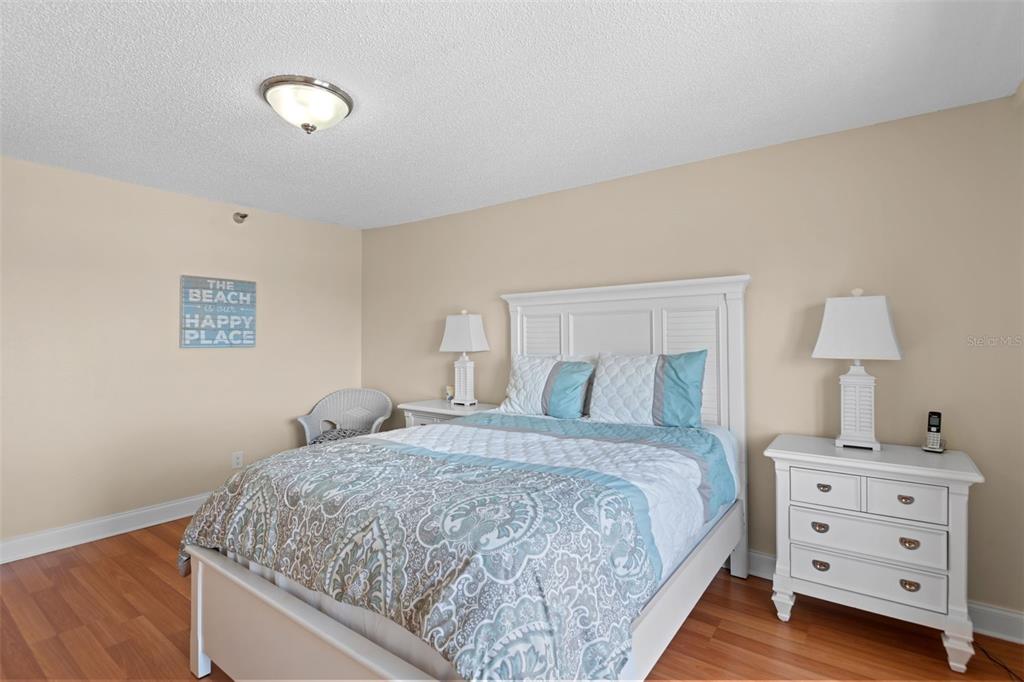 13440 Gulf Lane, Unit 202 Madeira Beach, FL 33708 - Photo 21 of 41 a bedroom with a bed and a lamp on dresser