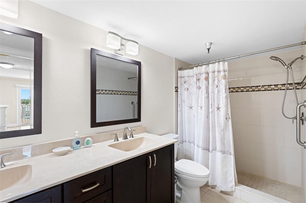 13440 Gulf Lane, Unit 202 Madeira Beach, FL 33708 - Photo 22 of 41 a bathroom with a sink toilet double vanity and shower