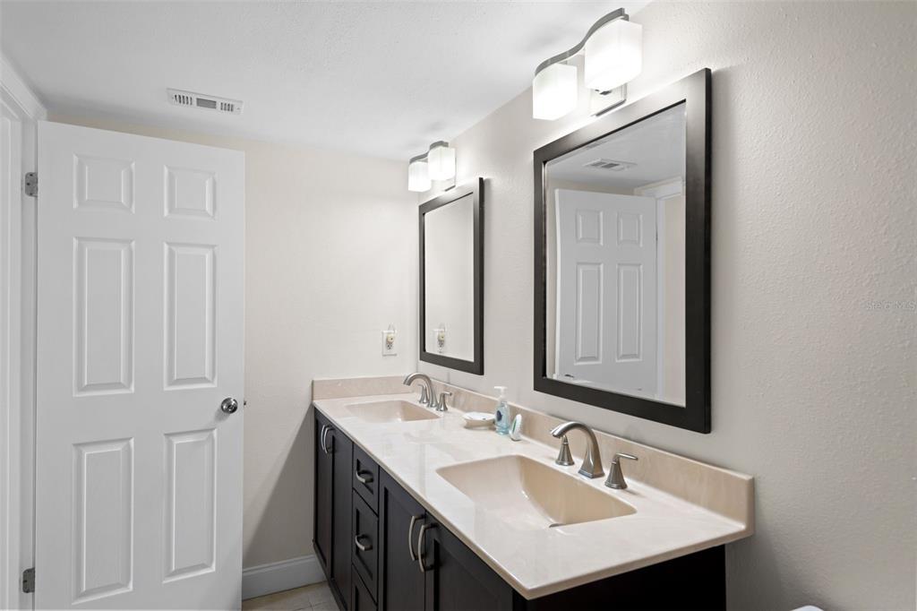 13440 Gulf Lane, Unit 202 Madeira Beach, FL 33708 - Photo 23 of 41 a bathroom with 2 sink and a mirror
