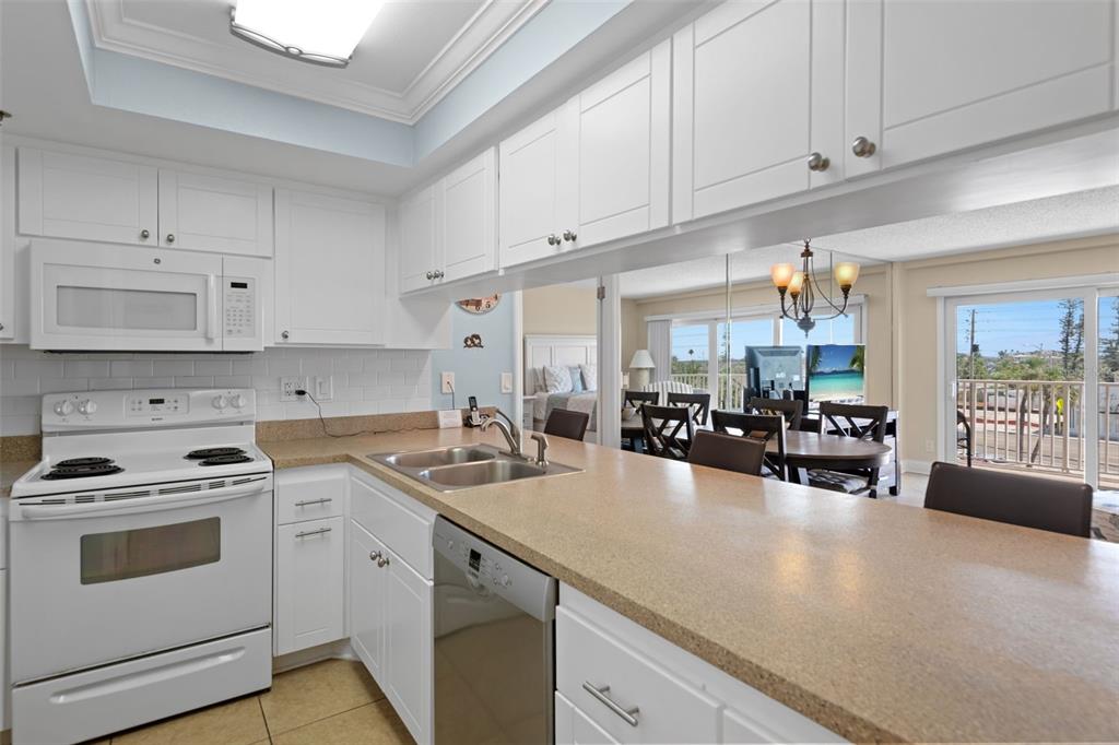 13440 Gulf Lane, Unit 202 Madeira Beach, FL 33708 - Photo 4 of 41 a kitchen with sink a stove and cabinets