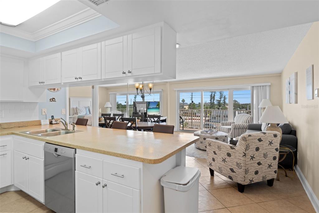 13440 Gulf Lane, Unit 202 Madeira Beach, FL 33708 - Photo 5 of 41 a kitchen with sink a stove and cabinets