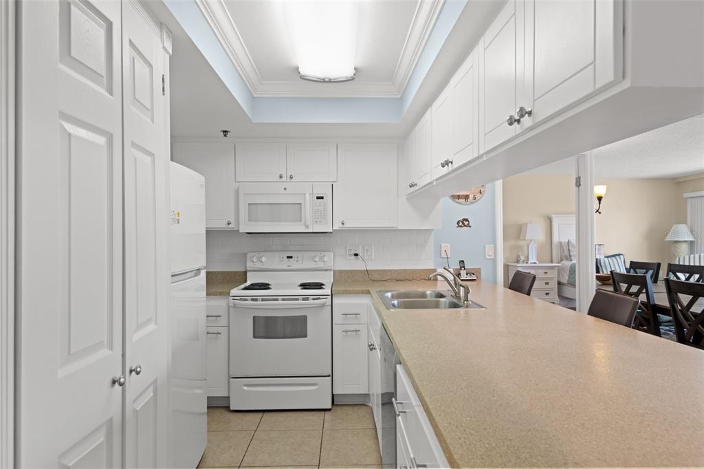 13440 Gulf Lane, Unit 202 Madeira Beach, FL 33708 - Photo 6 of 41 a kitchen that has a sink a stove and cabinets