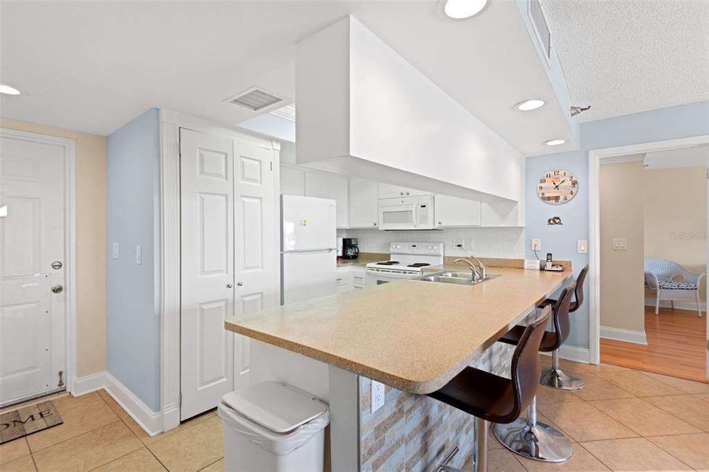 13440 Gulf Lane, Unit 202 Madeira Beach, FL 33708 - Photo 7 of 41 a large kitchen with a table and chairs in it