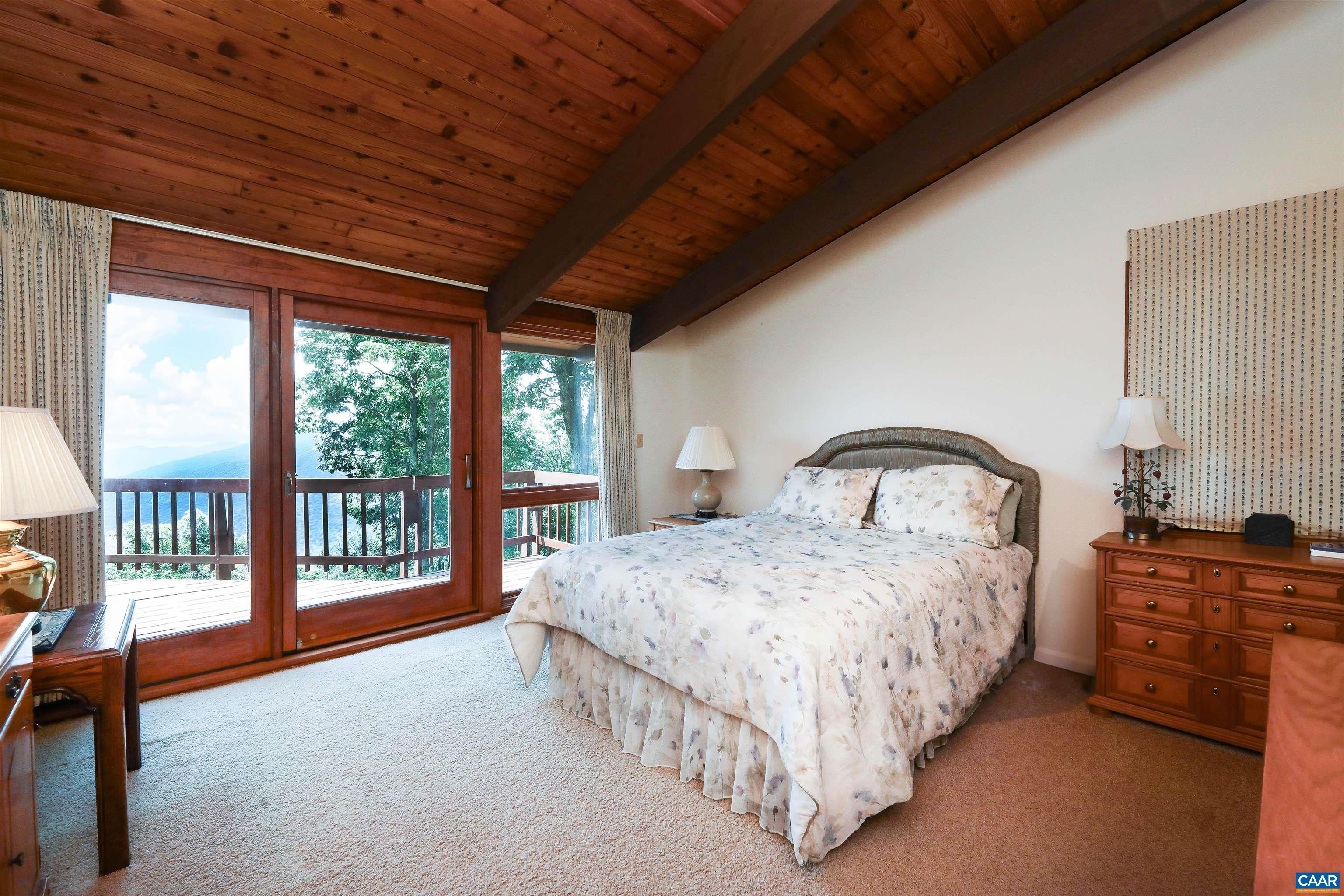 383 Cedar Drive Wintergreen, VA 22967 - Photo 25 of 47 a spacious bedroom with a bed and a large window with outer view