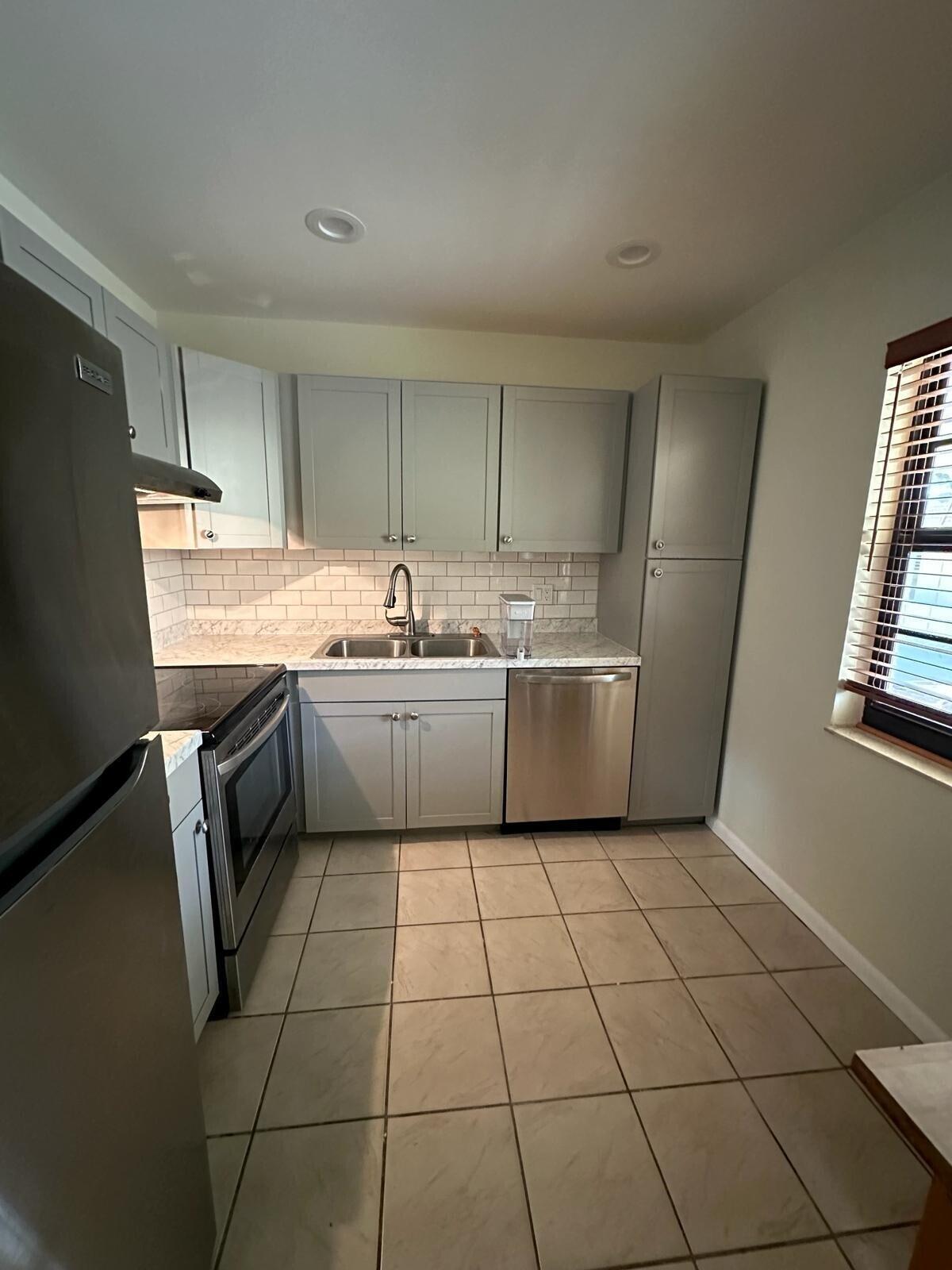 132 South Cypress Road, Unit 523 Pompano Beach, FL 33060 - Photo 3 of 25 a kitchen with a sink a refrigerator and window