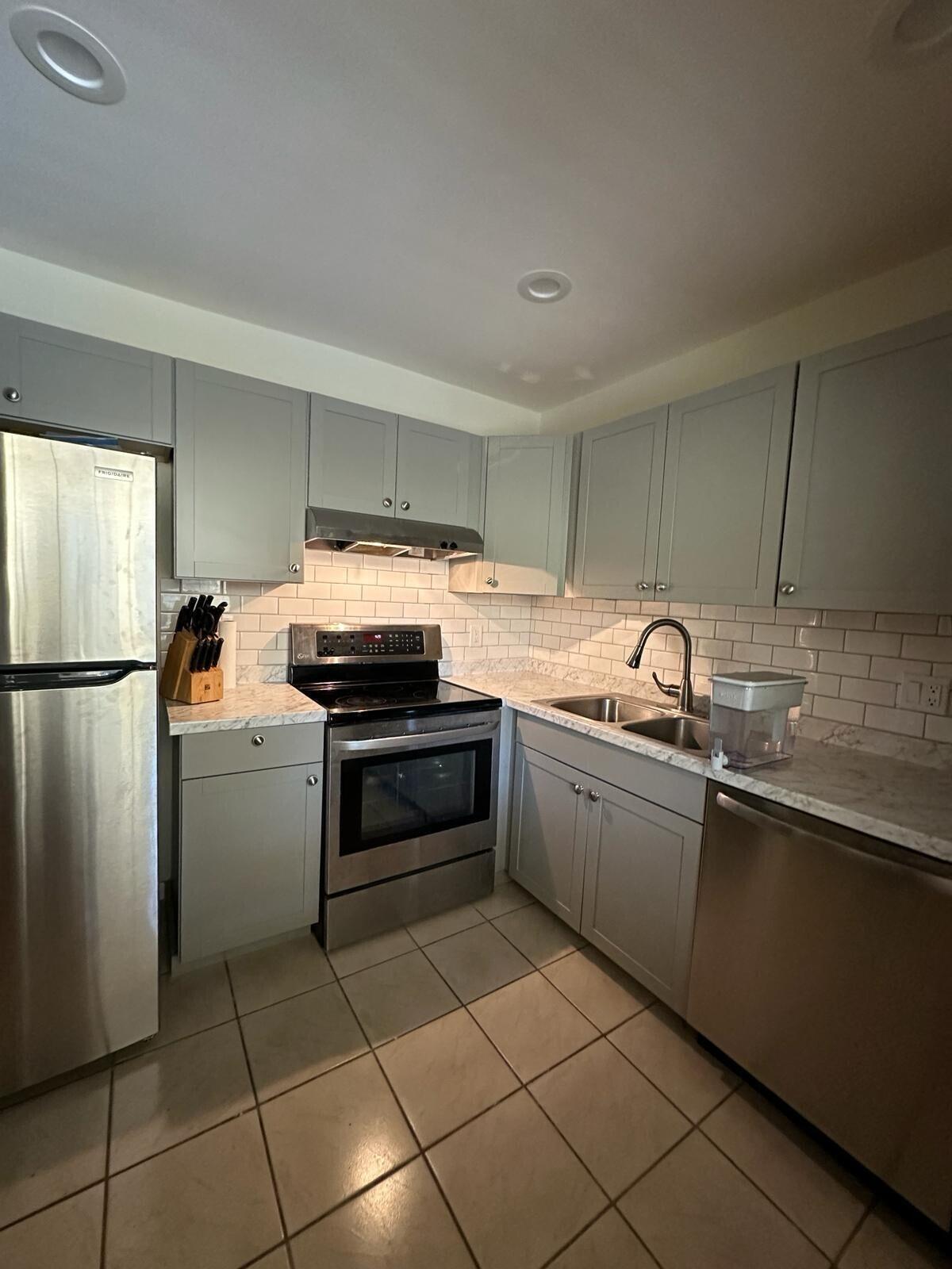 132 South Cypress Road, Unit 523 Pompano Beach, FL 33060 - Photo 4 of 25 a kitchen with a refrigerator and a sink