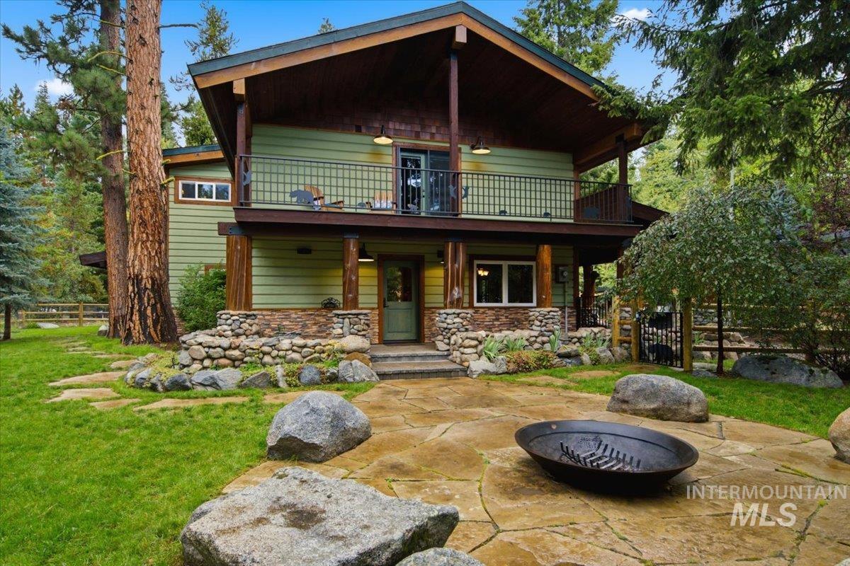 1029 Cee Way Loop McCall, ID 83638 - Photo 47 of 50 Landscaped yard with stone pathway, mature trees, wood siding, and stacked stone foundation