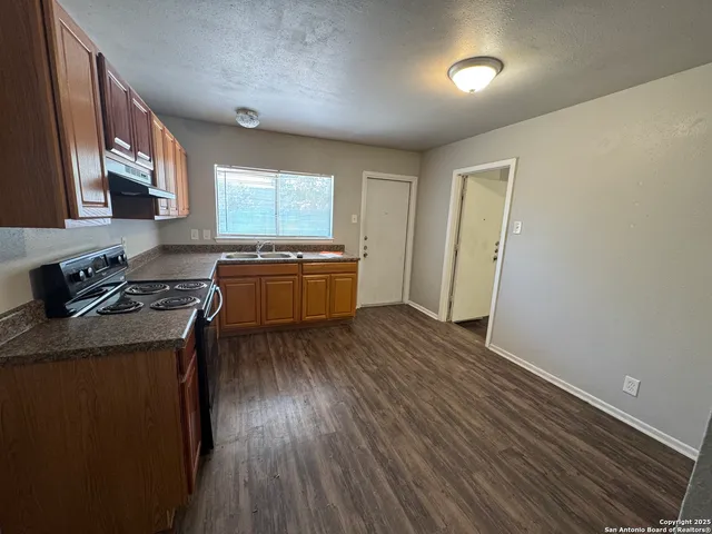 a kitchen with granite countertop wooden floors and sink