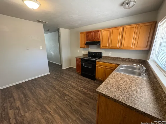 a kitchen with stainless steel appliances granite countertop a sink stove refrigerator and microwave