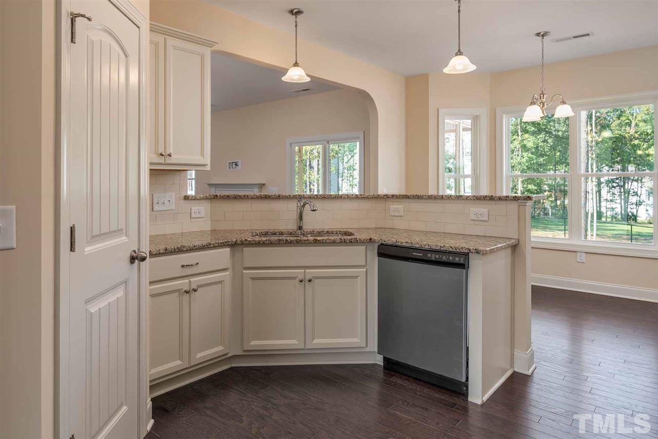 7208 Cornett Way Raleigh, NC 27604 - Photo 2 of 4 a kitchen with granite countertop white cabinets white appliances a sink and a large window