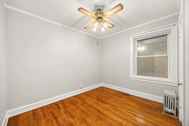 an empty room with a window and a ceiling fan