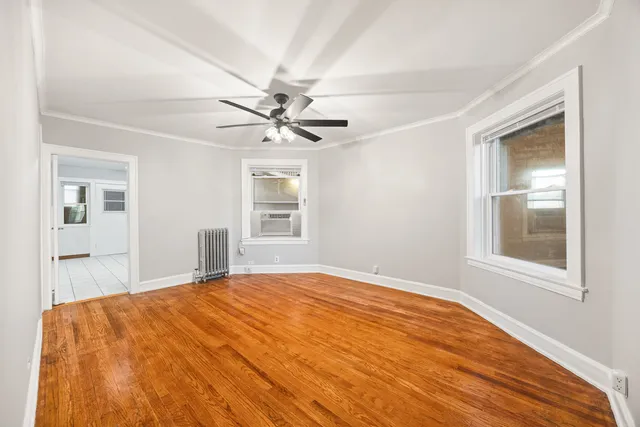 a bedroom with a large bed with wooden floor next to a window