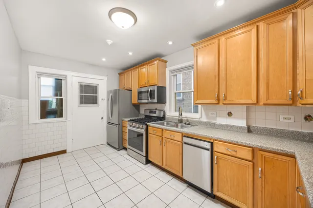 a kitchen with stainless steel appliances granite countertop a stove sink and cabinets