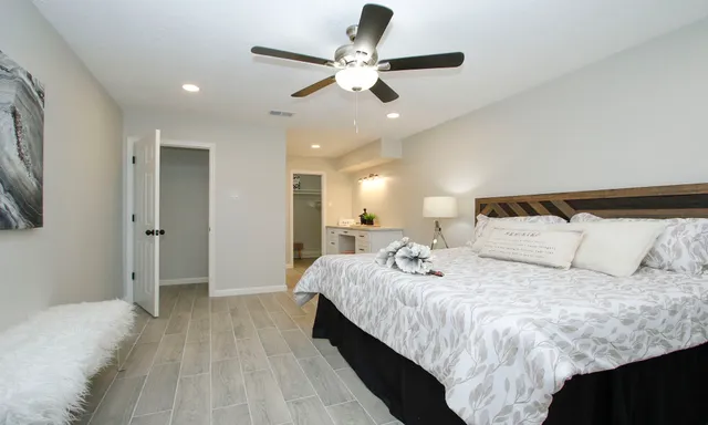 a spacious bedroom with a bed and a ceiling fan