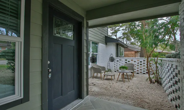 a view of a patio with table and chairs and floor to ceiling window