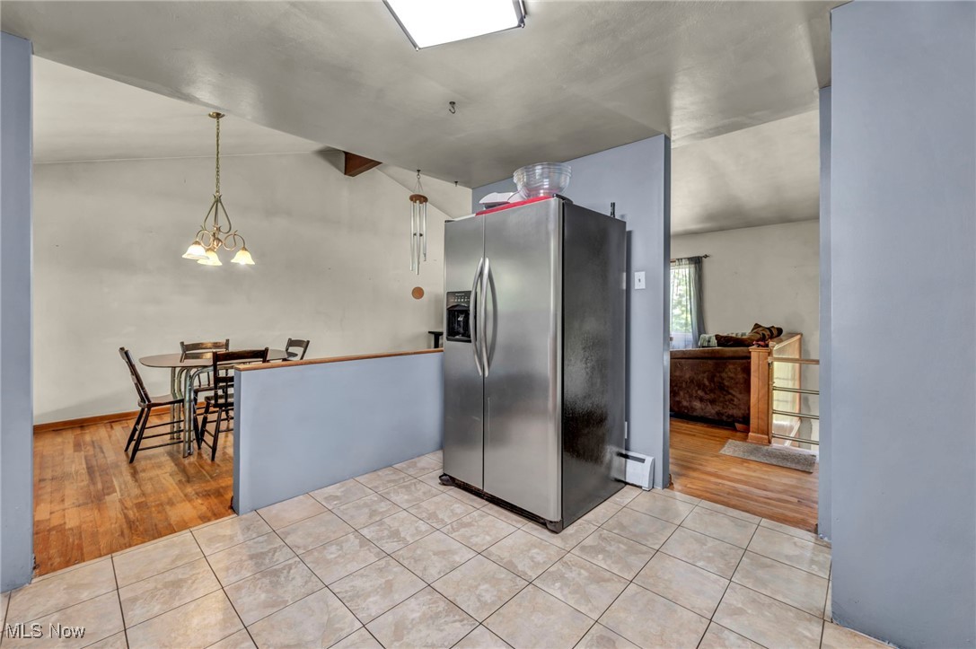 11996 Bower Road East Rochester, OH 44625 - Photo 7 of 49 Kitchen featuring stainless steel fridge, lofted ceiling, light tile patterned floors, and a chandelier