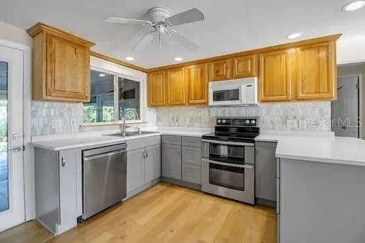 a kitchen with a stove a sink a microwave a dining table and chairs