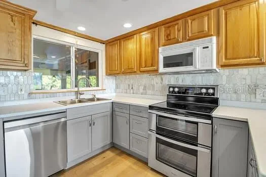 a large kitchen with stainless steel appliances granite countertop a stove and a refrigerator