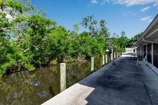 a view of a hallway with a dining area and chandelier fan