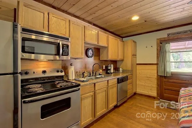 a backyard of a house with barbeque oven table and chairs